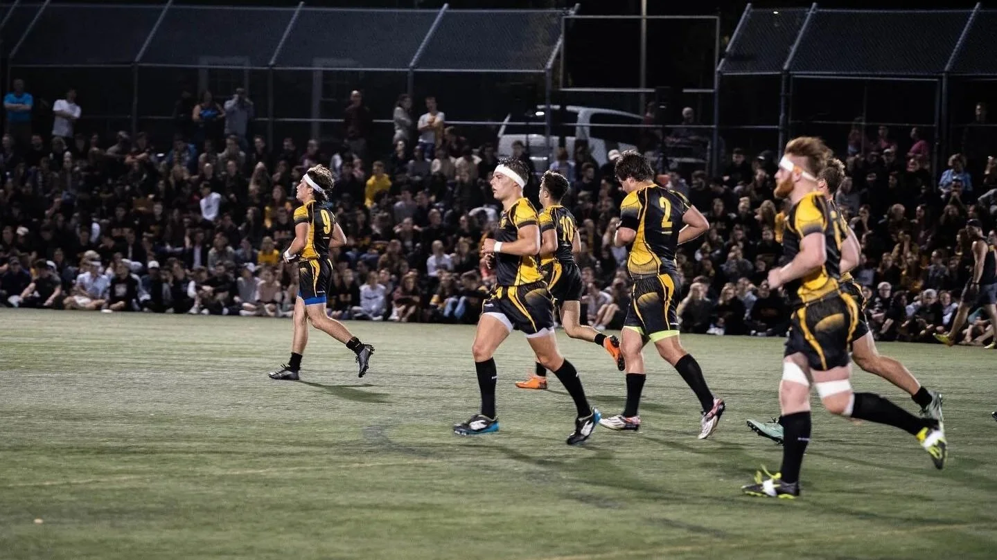 Dal Rugby players on the pitch under the lights in front of a big crowd